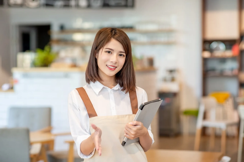 a woman in an apron holding a computer